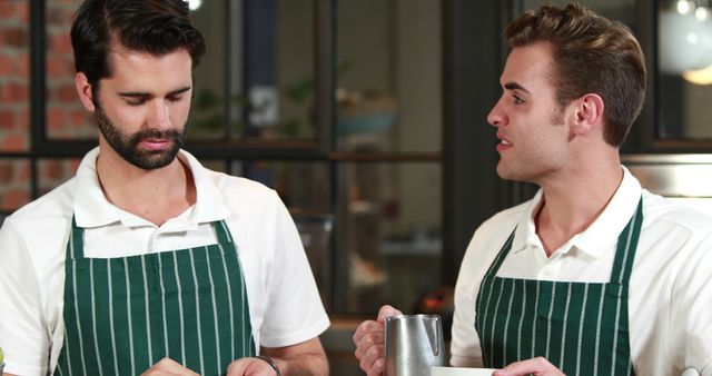 Two Young Professional Baristas Discussing Orders in a Cozy Cafe - Download Free Stock Images Pikwizard.com