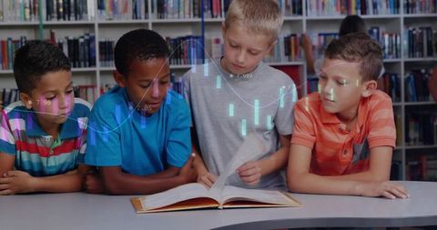 Four boys reading in school library leaning over open book, collaborating and learning