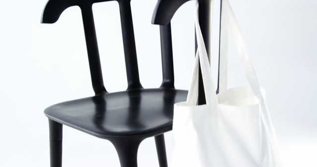 Minimalist Black Plastic Chair and White Tote Bag on White Background - Download Free Stock Images Pikwizard.com