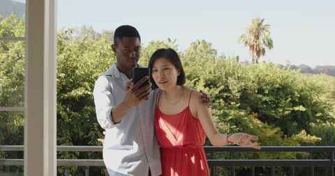 Couple Taking Selfie on Balcony with Scenic View