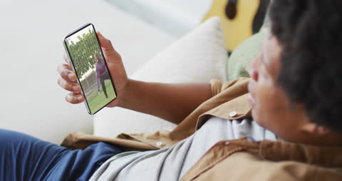 Man Watching Soccer Match on Smartphone at Home