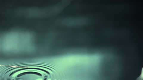 Still Syringe Hovering Above Water Causing Gentle Ripples