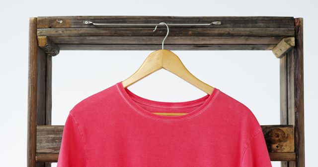 Close-up of t-shirt hanging on a wooden frame on white background