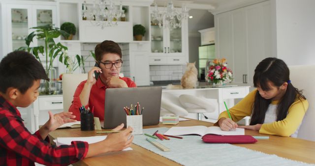 Busy father working remotely while children doing schoolwork at kitchen table - Download Free Stock Images Pikwizard.com