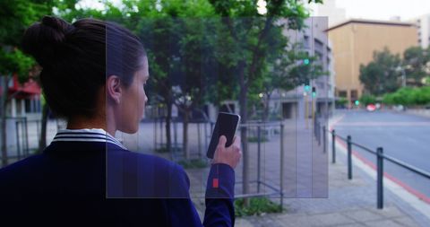 Businesswoman Analyzing Data on Smartphone in Urban Environment