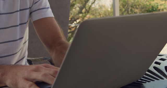 Young Man Working on Laptop Outdoors on Patio - Download Free Stock Images Pikwizard.com