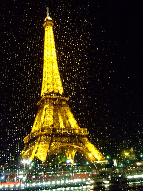 Perfect for travel blogs, romantic getaway promotions, Paris tourism ads, or as fine art for a modern home or office decor. Showcases the Eiffel Tower glowing brightly against a dark sky, with rain droplets adding a poetic touch. Ideal for conveying a sense of romance, iconic architecture, and captivating cityscapes.