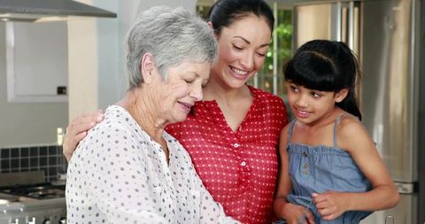 Multigenerational family cooking together in modern kitchen smiling preparing meal