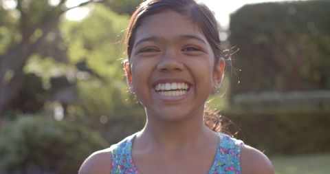 Smiling Young Girl in Summer Dress Enjoying Sunny Outdoors