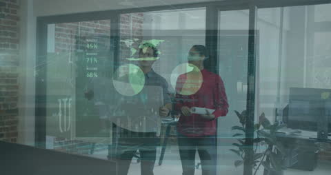 Modern office situation shows two colleagues discussing over technological data visualizations. Perfect for themes of teamwork, data analytics, business innovation, and collaborative working environments. Can enhance presentations, promotional banners, or websites related to technology and business development.