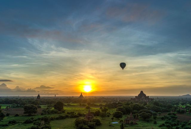Hot air balloon floating over ancient temples in Bagan during sunrise. Can be used for travel promotions, tourism campaigns, cultural heritage articles, and adventure travel inspirations.