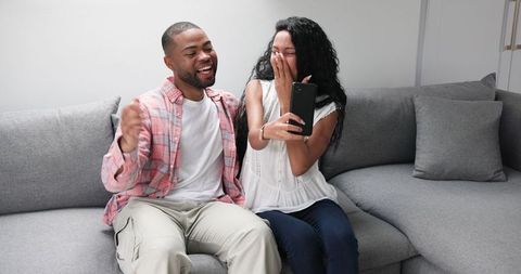 Engaged Couple Celebrating Excitement on Video Call at Home