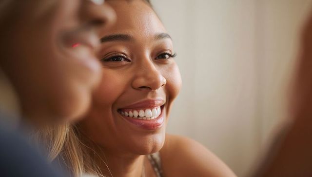 Smiling african american woman wearing necklace and tank top enjoying warm soft light