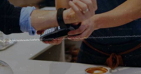 Smartwatch tapping contactless payment at coffee shop counter