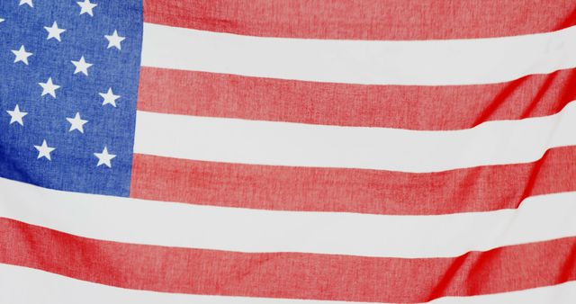 This image depicts a close-up view of the American flag, prominently displaying its stars and stripes pattern. The flag’s detailed fabric texture and vibrant colors make it ideal for use in materials celebrating American patriotism, national holidays such as Independence Day, educational resources, and any content discussing US national symbols.