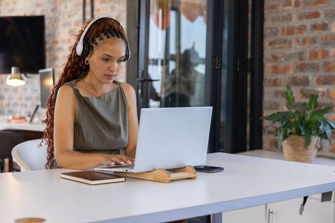 Focused Professional in Office Typing on Laptop