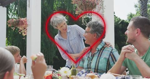 Family Enjoying Meal Outdoors with Heart Overlay Symbolizing Love