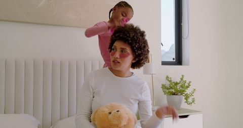 Laughing Mother and Daughter Engaging in Fun Hair Styling Activity
