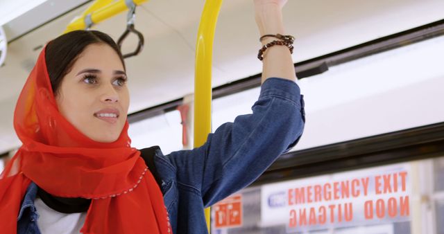 Confident Woman in Red Hijab Standing in Public Transport - Download Free Stock Images Pikwizard.com