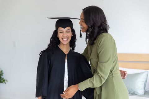 Mother Adjusting Daughter's Graduation Cap in Joyful Milestone Celebration