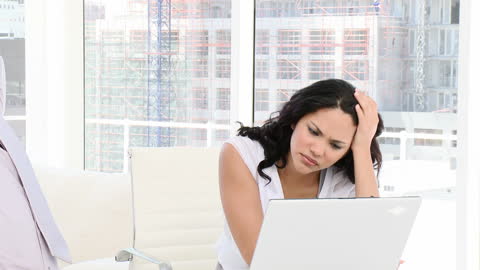 Frustrated Professional Woman Working on Laptop in Modern Office
