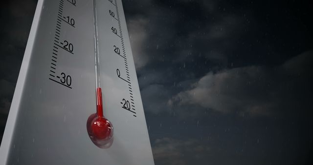 Close-up view of a thermometer indicating below freezing temperatures, set against a dark, cloudy night sky. This visual portrays cold, harsh winter conditions and could be used in weather forecasts, climate reports, or winter season promotions.