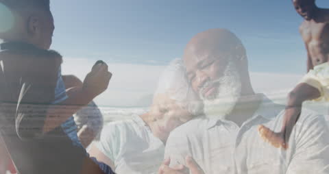 Senior Couple Embracing on the Beach with Family