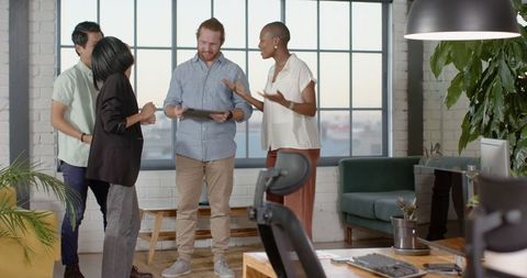 Diverse Team Excitedly Celebrating Success with Tablet