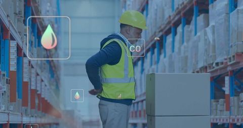 Warehouse Worker Checking Boxes on Pallet with CO2 and Sensor Overlays for Smart Logistics