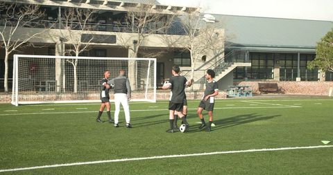 Youth soccer players practicing ease passing on school field