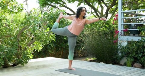 African American Woman Practicing Yoga Outdoors on Deck