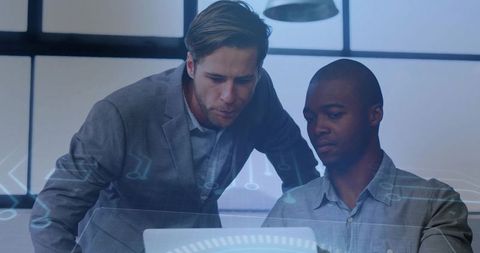 Business colleagues analyzing data on laptop with holographic HUD overlay