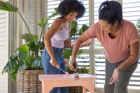 Mother and daughter in porch painting project with wooden bench