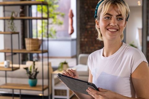 Smiling Woman Using Tablet in Modern Loft Interior with Natural Light