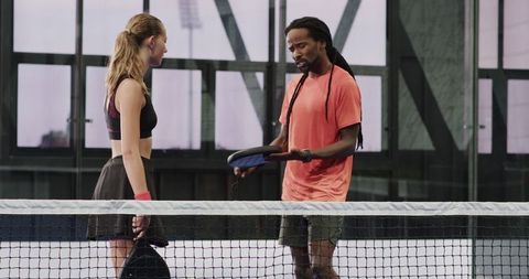 Diverse padel players planning strategy on indoor court