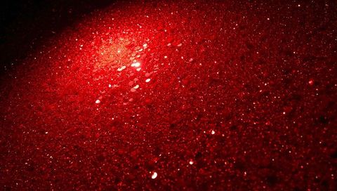 Crimson glitter macro texture with sparkling bokeh, metallic shine and red sequin close-up