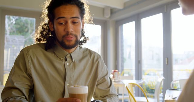 Casual Man Sipping Coffee in Cozy Cafe Daylight - Download Free Stock Images Pikwizard.com