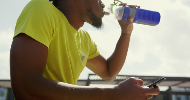 Male Athlete Drinking Water while Using Smartphone Outdoor - Download Free Stock Images Pikwizard.com