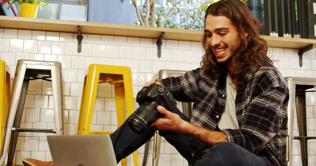 Young male photographer reviewing DSLR camera settings in casual modern café - Download Free Stock Images Pikwizard.com