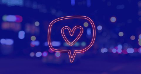 Neon Heart Icon Against Blurred City Nightscape
