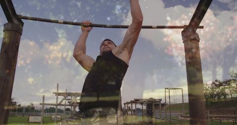 Fit man engaging in pull-up at outdoor fitness park