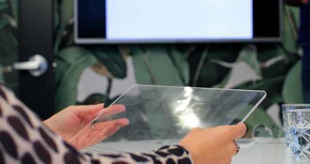 Person using transparent tablet during business meeting with presentation screen - Download Free Stock Images Pikwizard.com