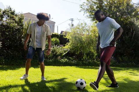 Two Friends Engaging in a Friendly Soccer Match on Sunny Day