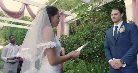 Bride reciting vows in elegant outdoor wedding ceremony