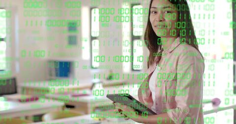 Instructor Holding Tablet Teaching Digital Coding with Green Binary Overlay in Classroom