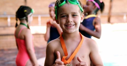 Joyful Boy Celebrating with Gold Medal at Poolside