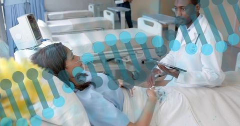 Doctor consulting tablet beside reclining patient on hospital bed with dna data overlay