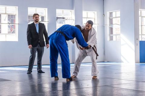 Diverse Athletes Engaged in Intense Judo Match with Referee