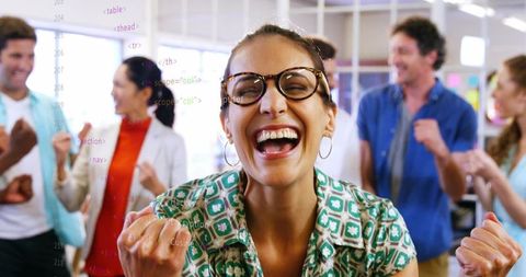 Enthusiastic team celebrating achievement in modern office