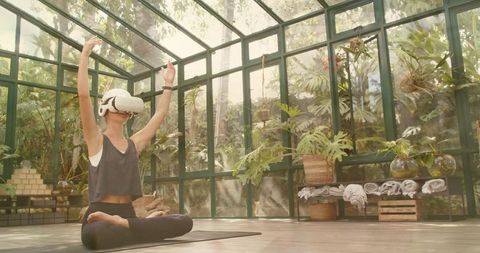 Practicing VR Meditation in Sunlit Greenhouse with Tropical Plants and Yoga Mat